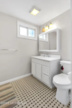 a bathroom with a sink toilet vanity and window