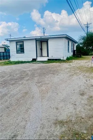 a front view of house with yard and trees around