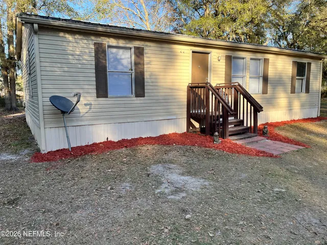 a view of a house with a backyard