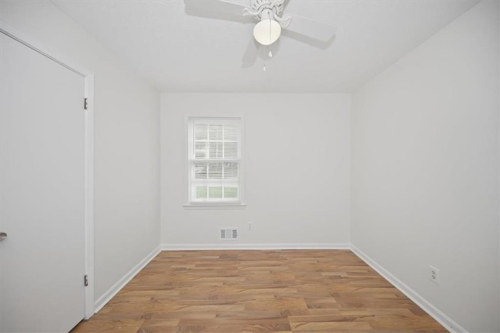 1496 Cherry Hill Road Southwest Conyers, GA 30094 - Photo 21 of 32 an empty room with a chandelier fan and windows