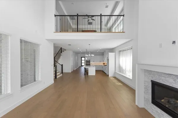 a living room with stainless steel appliances furniture a fireplace and entryway