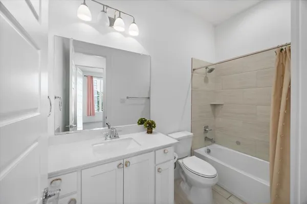 a bathroom with a sink a toilet a mirror a bathtub and shower