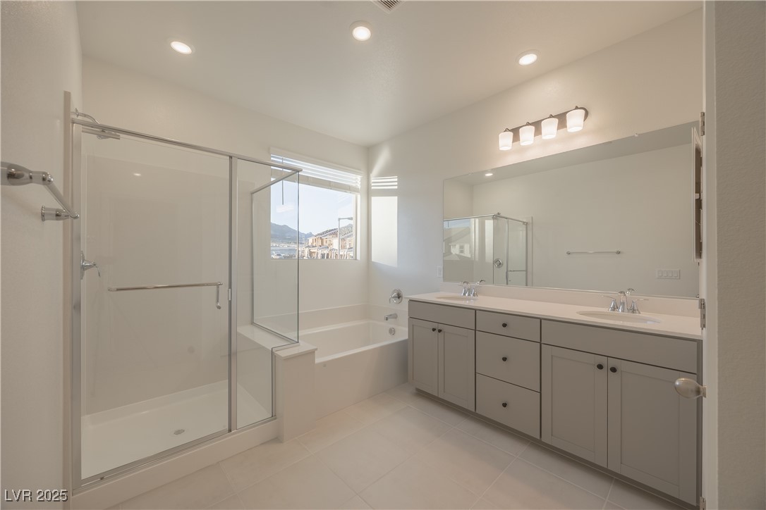 95 Silver Run Lane Las Vegas, NV 89138 - Photo 12 of 18 Bathroom featuring double vanity, a stall shower, a bath, recessed lighting, and light tile patterned floors