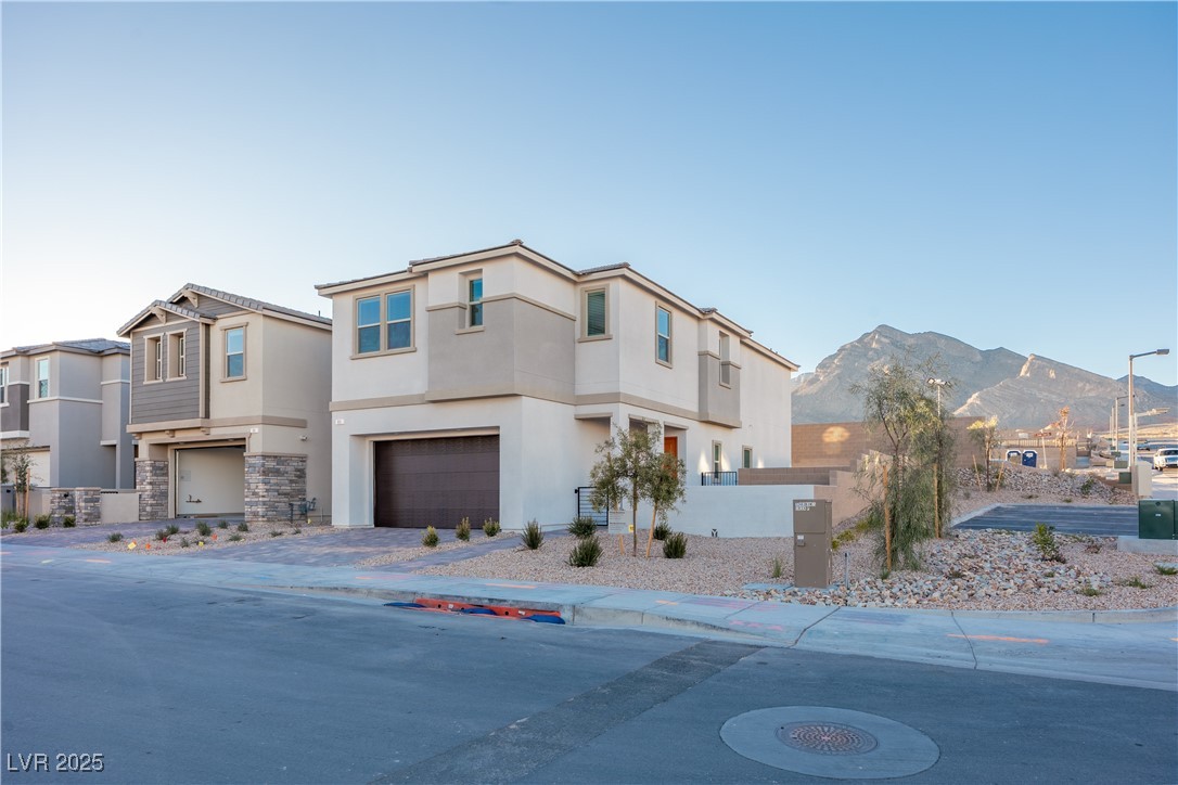 95 Silver Run Lane Las Vegas, NV 89138 - Photo 2 of 18 View of front of home featuring a residential view, stucco siding, a garage, and driveway