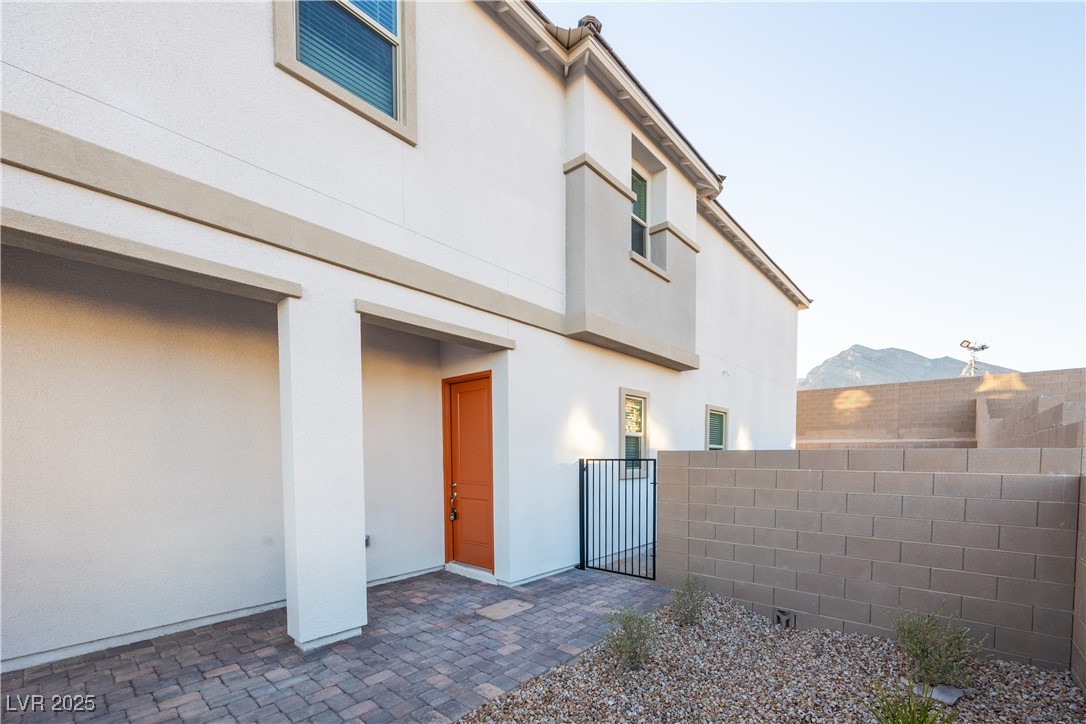 95 Silver Run Lane Las Vegas, NV 89138 - Photo 3 of 18 View of side of property featuring stucco siding and a gate