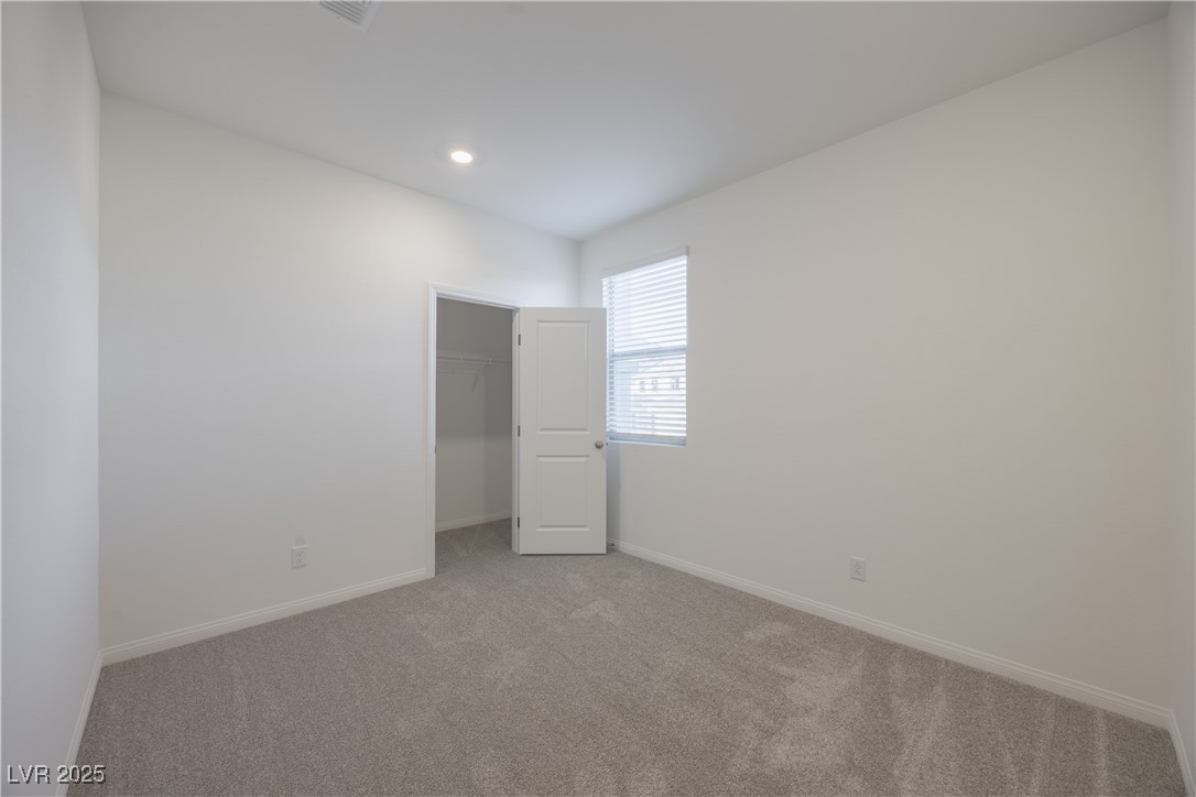 95 Silver Run Lane Las Vegas, NV 89138 - Photo 7 of 18 Unfurnished bedroom featuring a walk in closet, light colored carpet, and recessed lighting