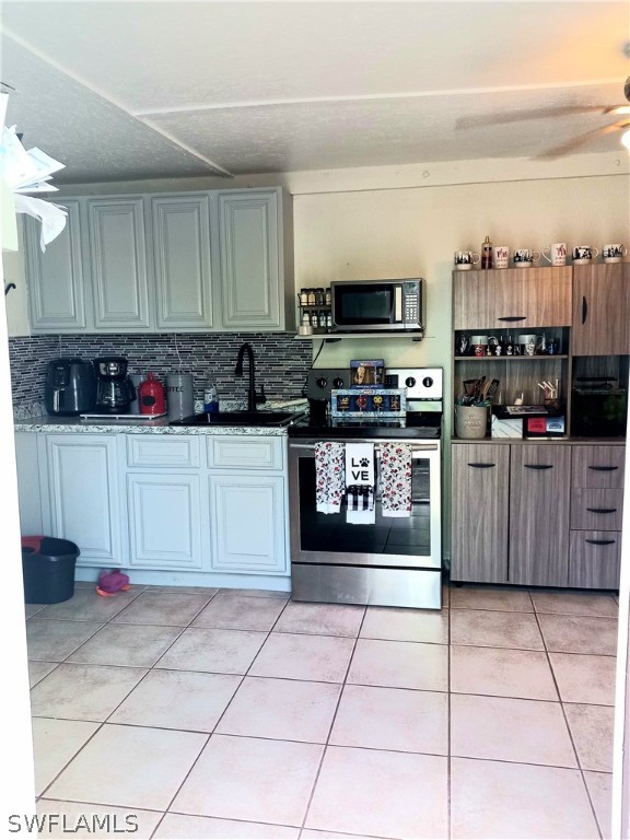 101 Oregon Road North Lehigh Acres, FL 33936 - Photo 18 of 41 a kitchen with stainless steel appliances a sink a stove a microwave cabinets and a counter top space