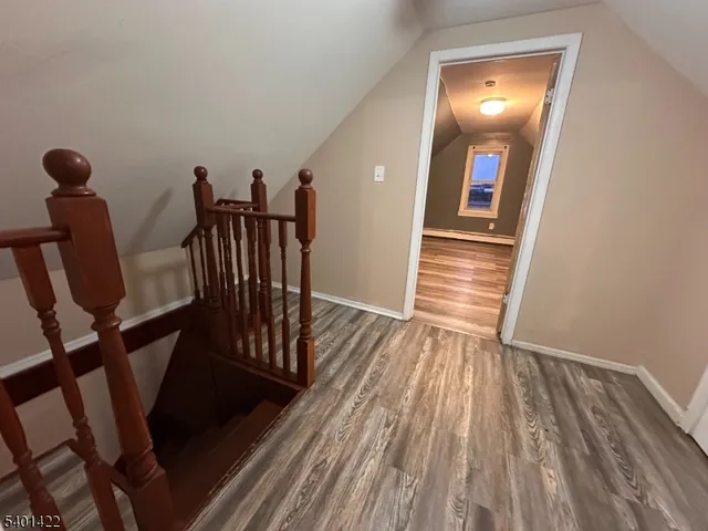 a view of a hallway with furniture and wooden floor