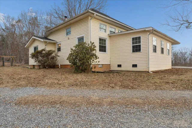 a view of a house with a small yard and wooden fence
