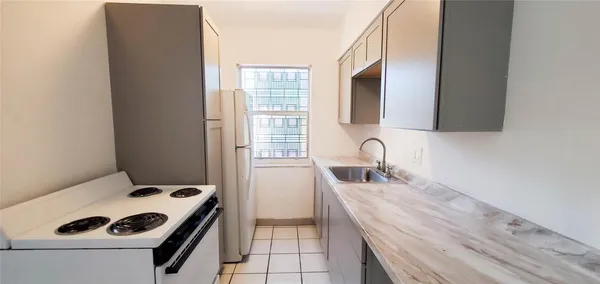 a kitchen with a sink a stove and cabinets