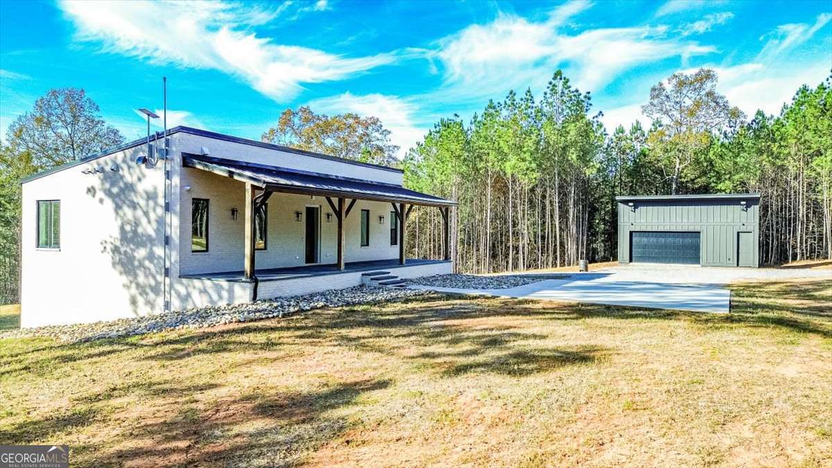 a view of house with swimming pool and trees in the background