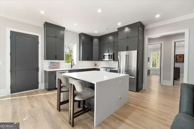 a kitchen with stainless steel appliances a refrigerator a stove a sink dishwasher and a refrigerator with wooden floor