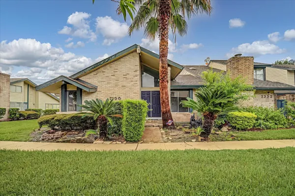 a front view of a house with a garden and patio