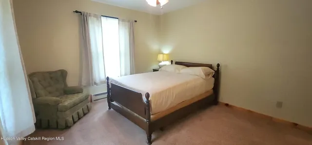 a bedroom with a bed couch and a window