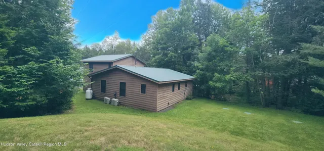 a view of a house with a yard and large tree