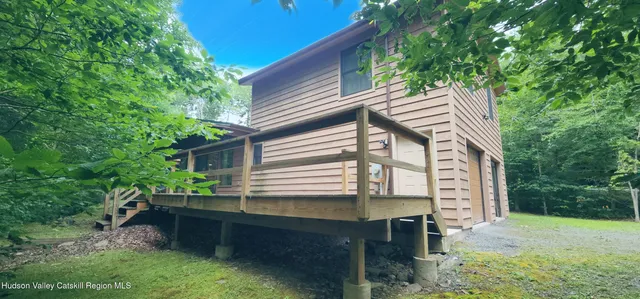 a backyard of a house with wooden fence and large trees