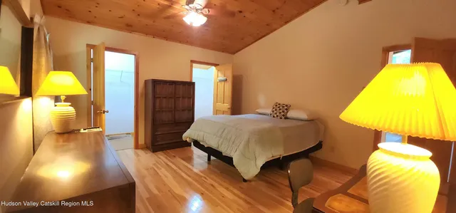 a spacious bedroom with a bed and a lamp