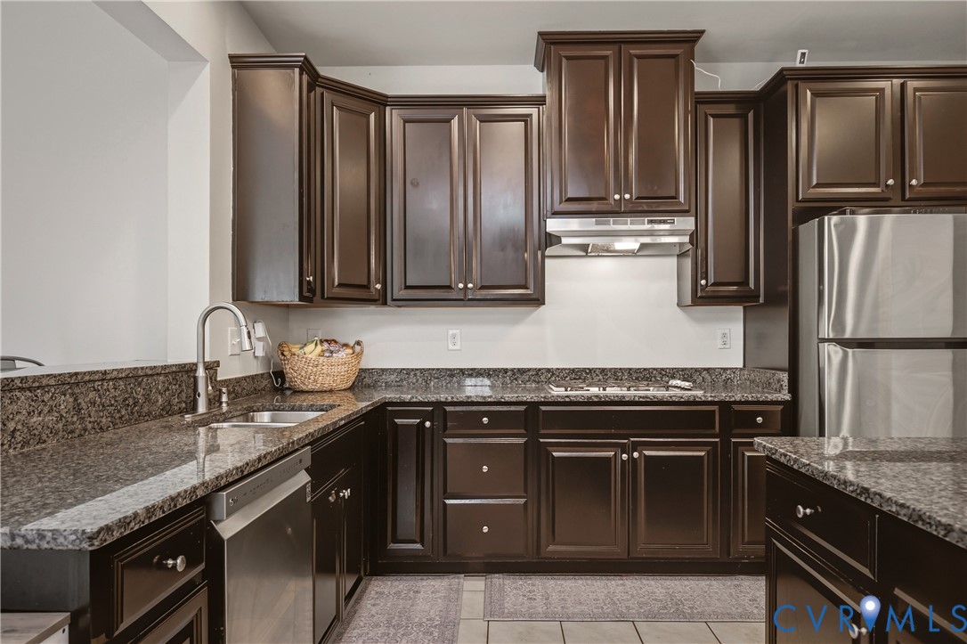 9013 Bailey Hill Road Midlothian, VA 23112 - Photo 24 of 56 Kitchen featuring dark wood cabinetry, granite cou