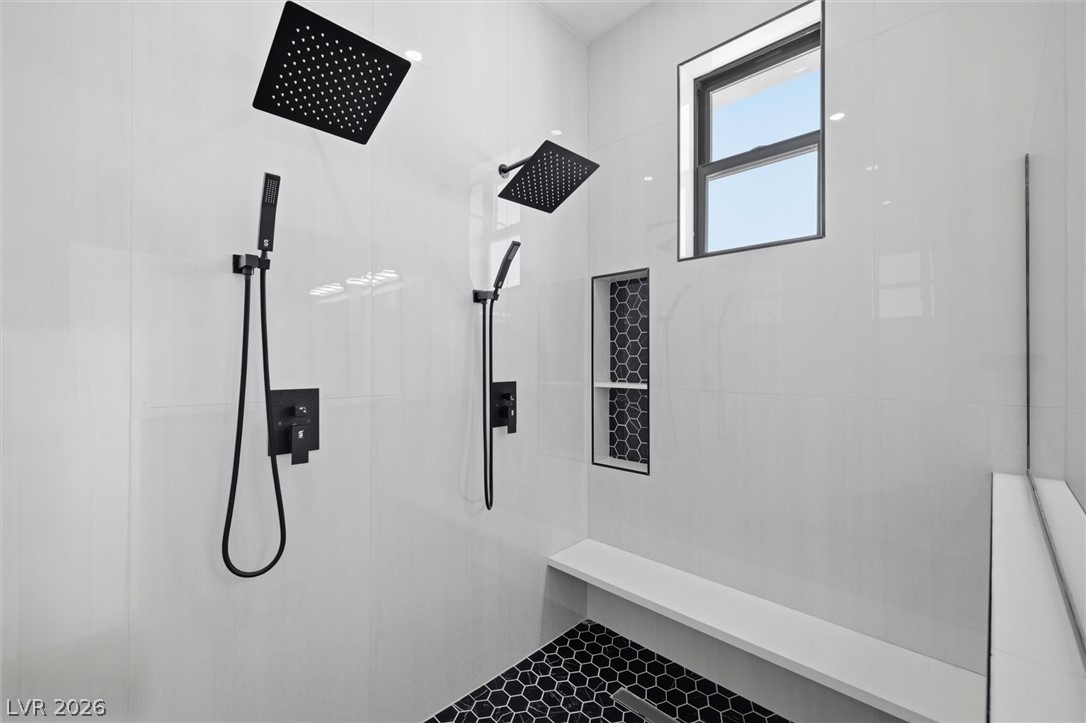 5910 East Kellogg Road Pahrump, NV 89061 - Photo 34 of 58 Dual rainfall showerheads and sleek black hexagonal tile flooring define this modern bath space.