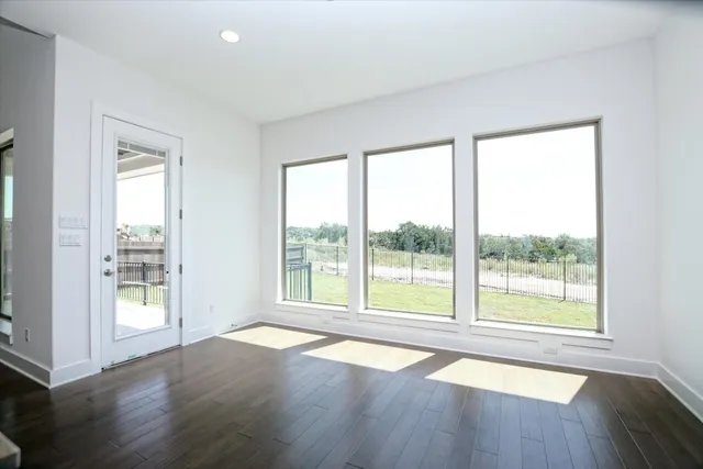 a view of a hallway with a door and wooden floor
