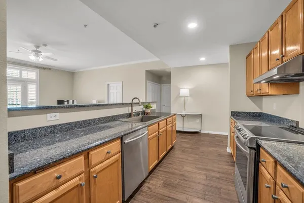 a large kitchen with stainless steel appliances granite countertop a sink stove and cabinets