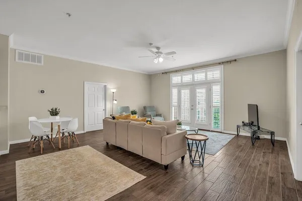 a living room with furniture floor to ceiling window and wooden floor