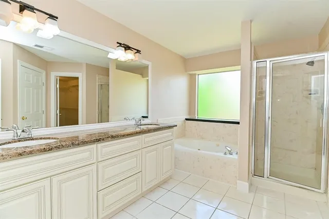 a bathroom with a granite countertop sink a mirror and a bathtub