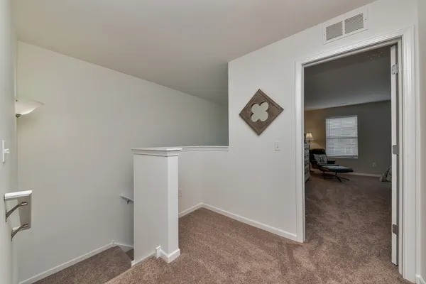 a view of a livingroom with furniture and a hallway