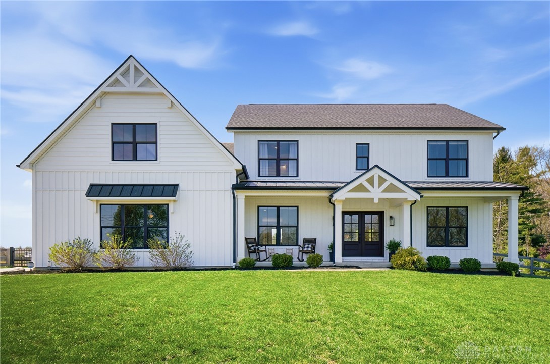 This classic white farmhouse presents inviting curb appeal and a serene setting.