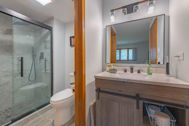 a bathroom with a granite countertop sink a toilet and a mirror