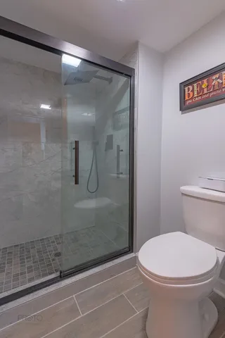 a bathroom with a toilet and a shower