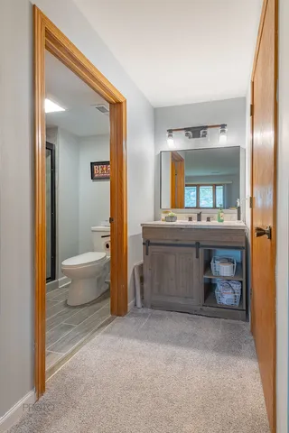 a bathroom with a sink a toilet and a mirror