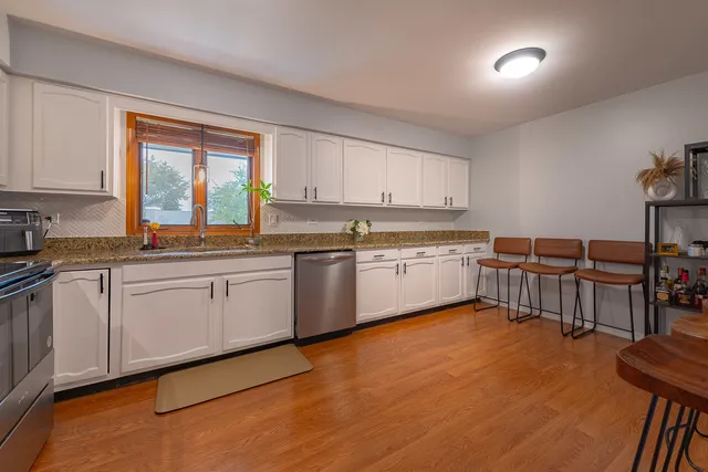 a kitchen with a sink window and cabinets