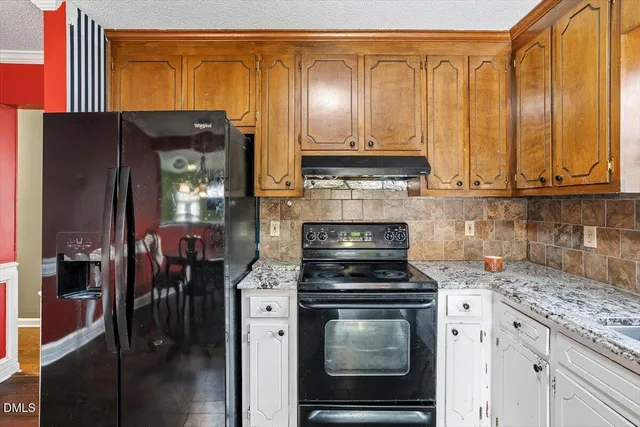 a kitchen with stainless steel appliances granite countertop a stove a refrigerator and a microwave