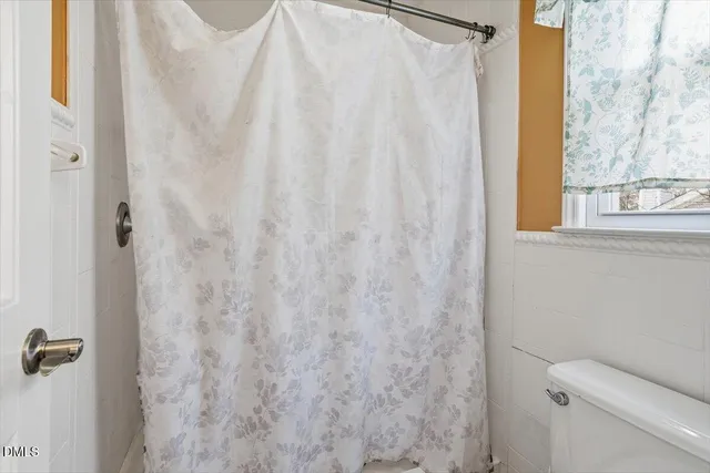 a bathroom with a shower curtain and a window