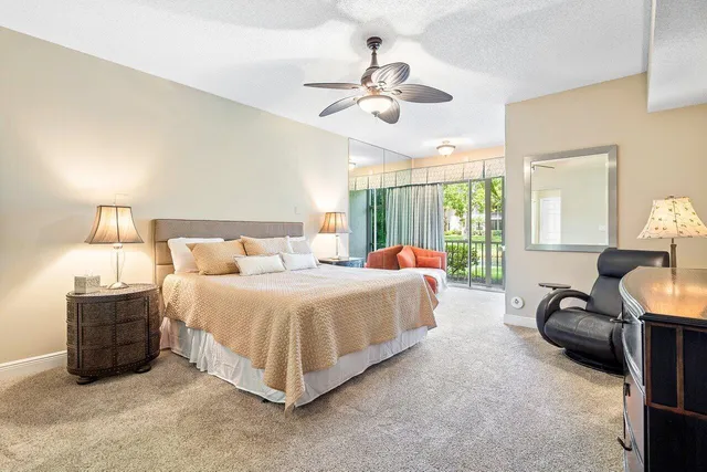 a spacious bedroom with a bed and ceiling fan