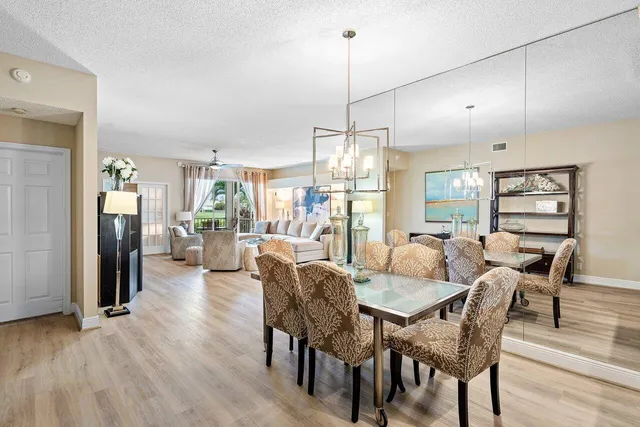 a dining room with furniture a chandelier and wooden floor