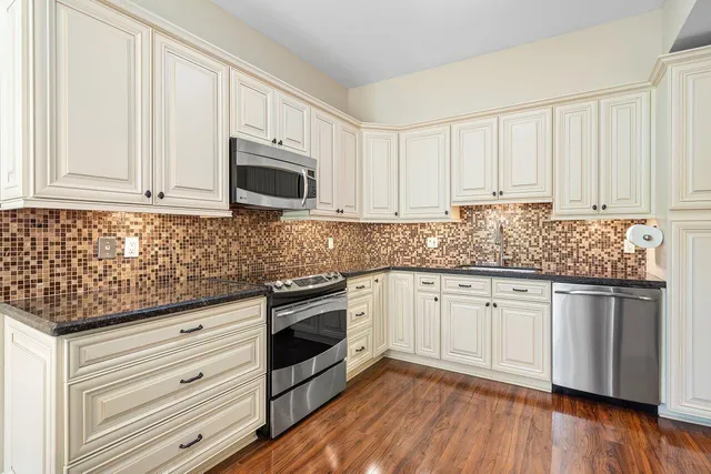a kitchen with granite countertop wooden cabinets and white appliances