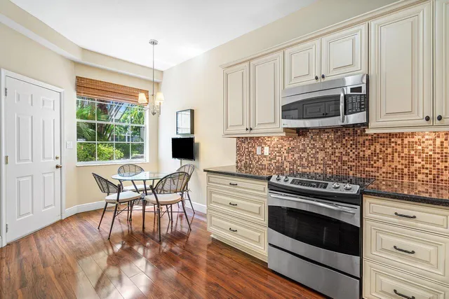 a kitchen with stainless steel appliances a stove a sink and white cabinets