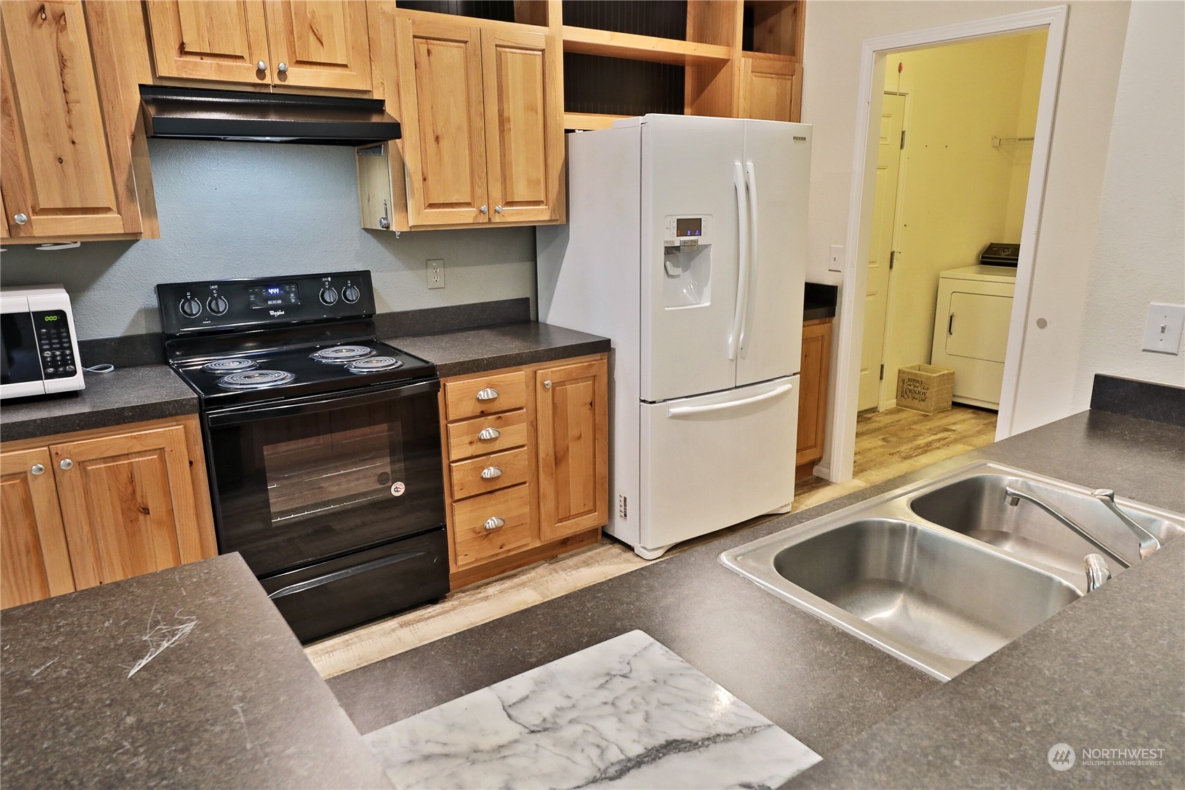 2811 East Andreason Road Langley, WA 98260 - Photo 19 of 38 a kitchen with granite countertop a refrigerator stove and sink