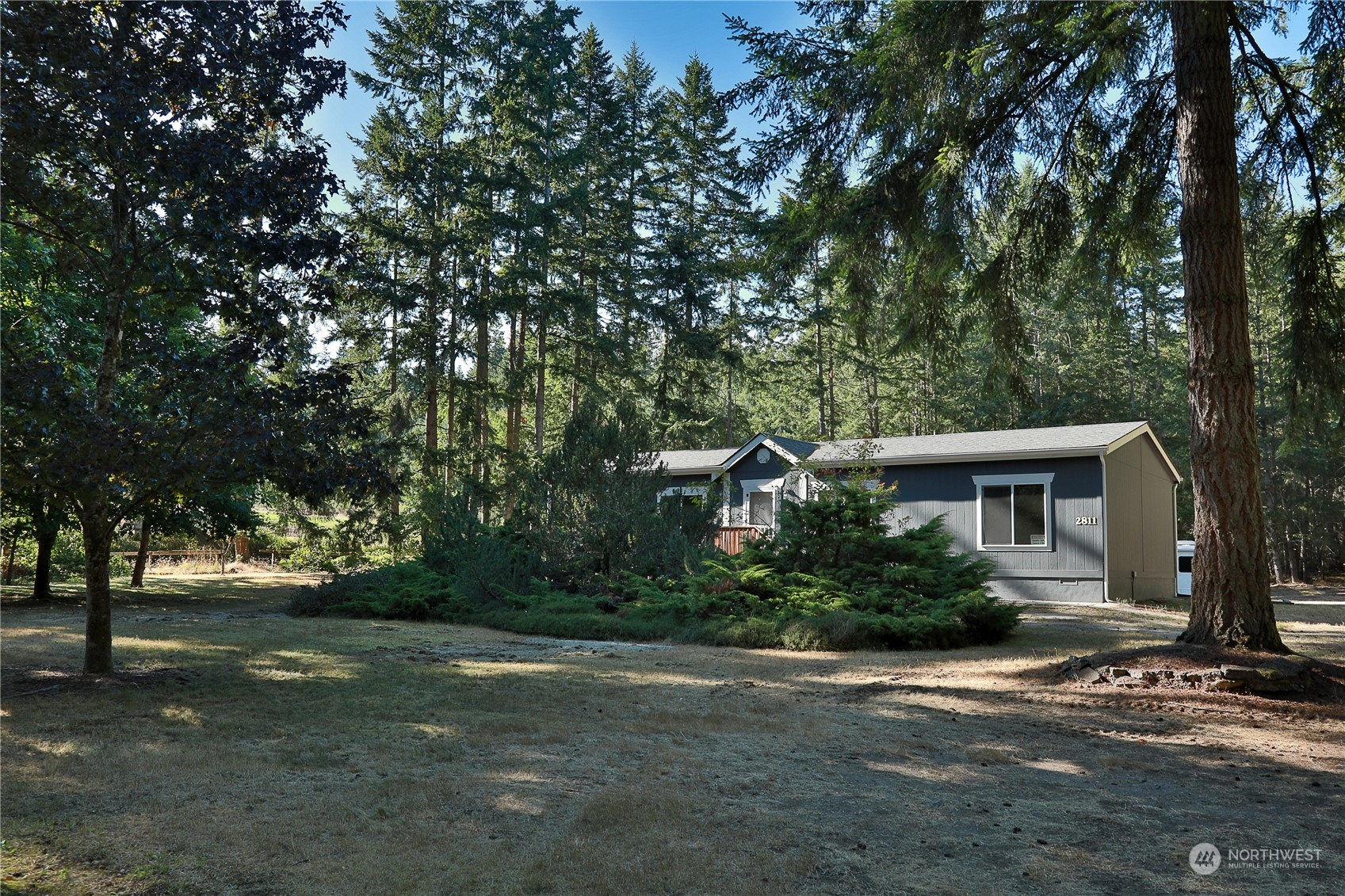 2811 East Andreason Road Langley, WA 98260 - Photo 2 of 38 a front view of a house with a yard and trees