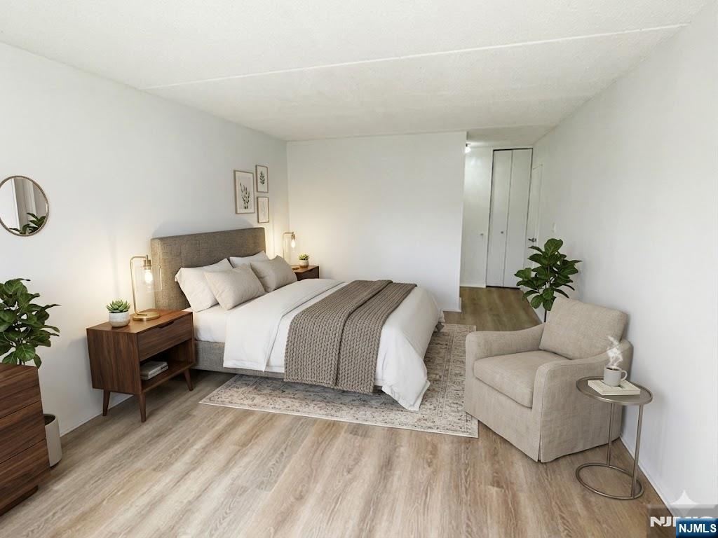 1055 River Road, Unit 1004 Edgewater, NJ 07020 - Photo 13 of 23 a bedroom with a bed table flowerpot and couch