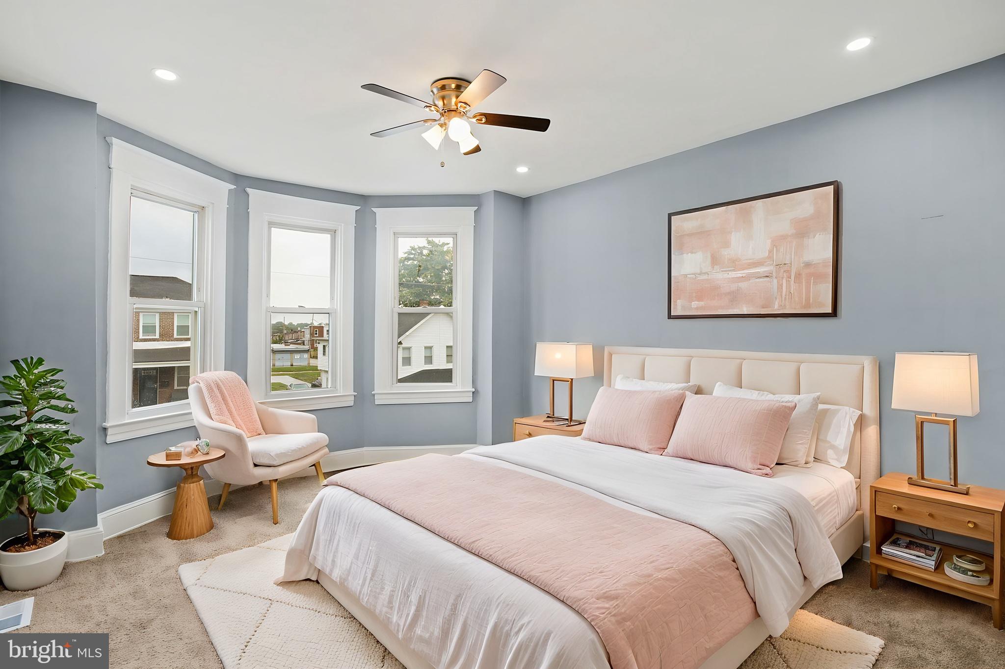 2811 Erdman Avenue Baltimore, MD 21213 - Photo 10 of 17 a spacious bedroom with a bed a couch and potted plant