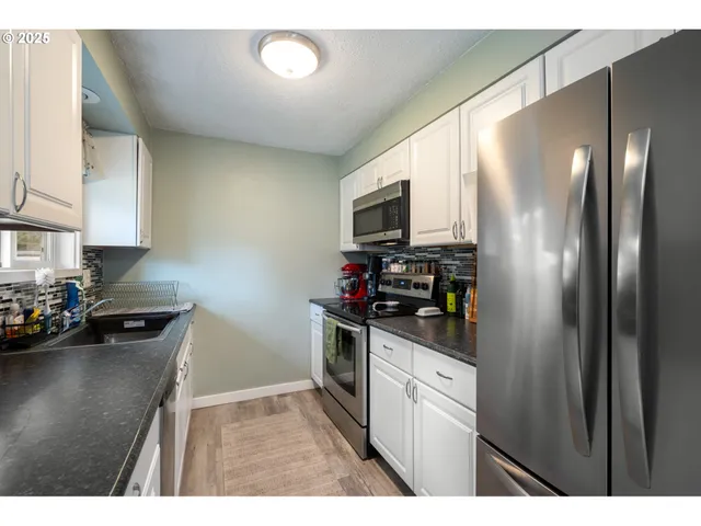 a kitchen with a refrigerator stove and sink
