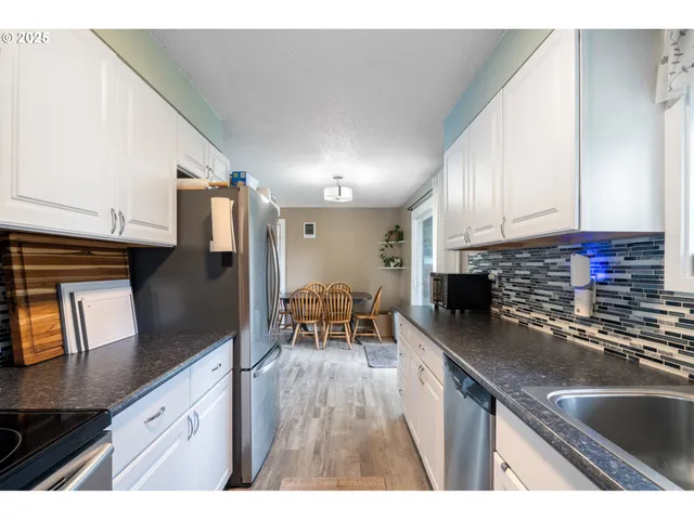a kitchen with stainless steel appliances granite countertop a sink a stove counter space and cabinets