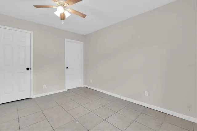an empty room with a chandelier fan