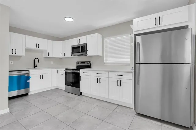 a kitchen with white cabinets and white appliances