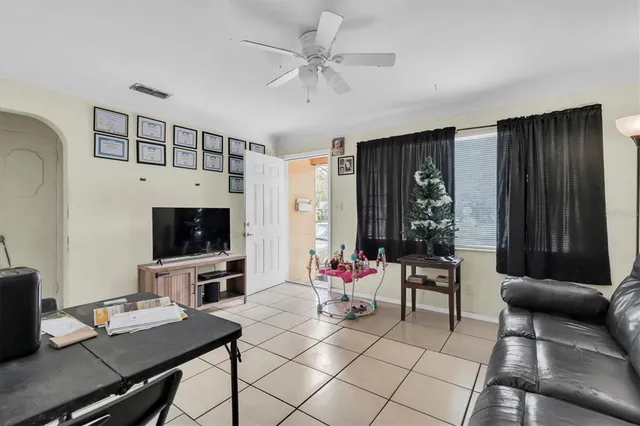 a living room with furniture a flat screen tv and a window