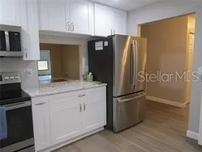 a kitchen with stainless steel appliances granite countertop a refrigerator and a stove top oven