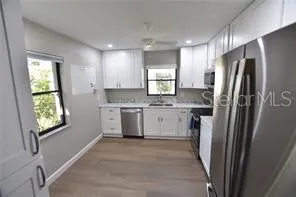 a kitchen with a refrigerator sink and cabinets